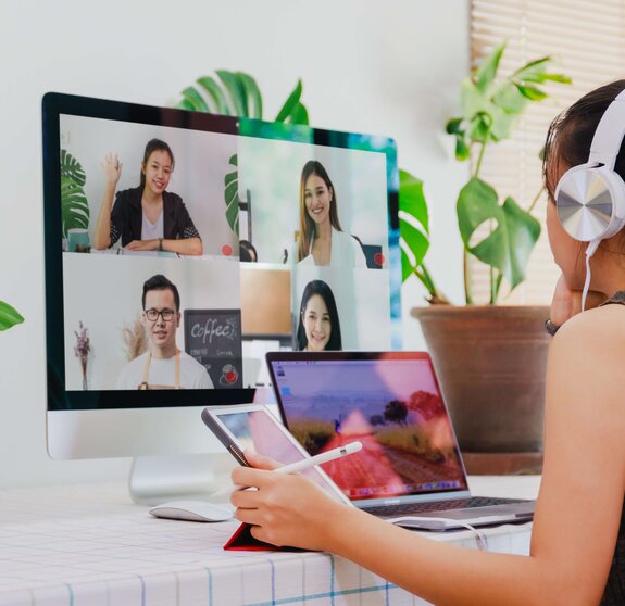 Asian business woman work from home with laptop, tablet and computer on table with meeting online and video conferencing.Concept of social distancing to stop the spread disease of Corona virus. 