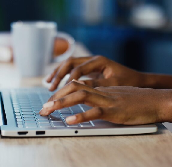 Close up shot of female hands typing on laptop