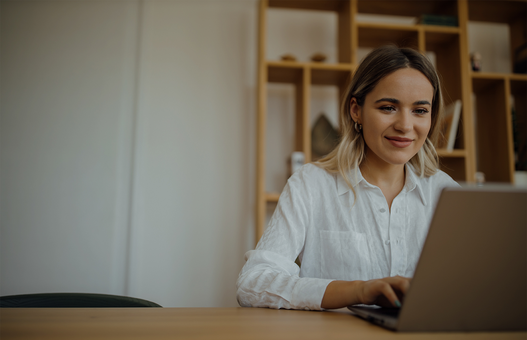 Young beautiful woman working on laptop at home office, copy space, portrait.