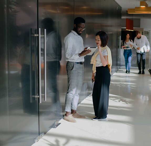 Diverse people in spacious office while discussing work questions