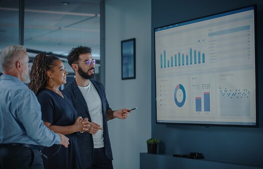 Company Operations Manager Holds Meeting Presentation. Diverse Team Uses TV Screen with Growth Analysis, Charts, Statistics and Data. People Work in Business Office.