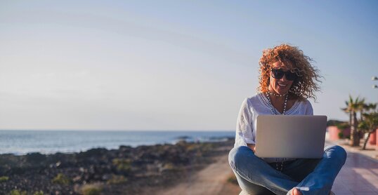 Happy lifestyle digital nomad young cheerful woman work outdoor with laptop computer - people and modern technology job and communication related - alternative office at the beach