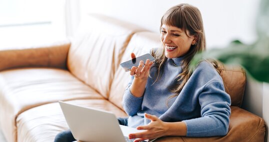 Happy young businesswoman having a phone call discussion in an office