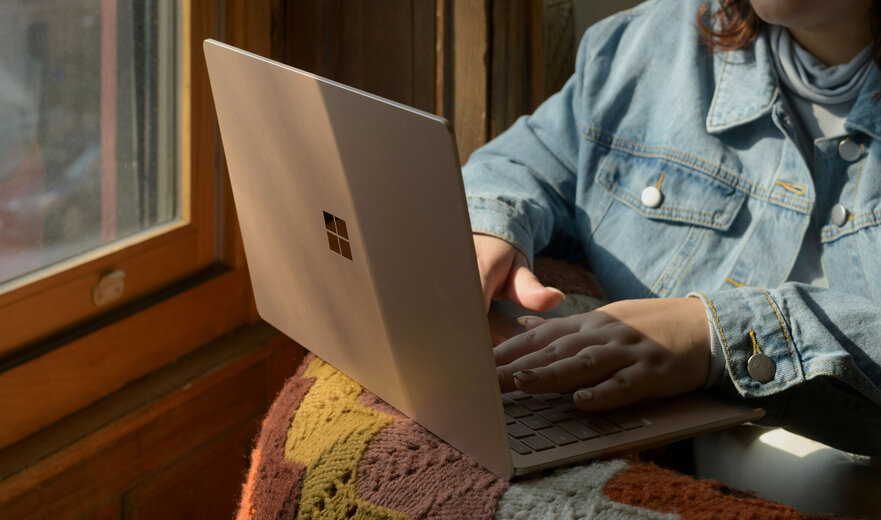 Eine Frau, die mit einem Laptop auf einem Stuhl sitzt