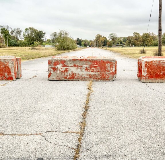Rote Zementblöcke, die auf einer Straße eine Barriere bilden.