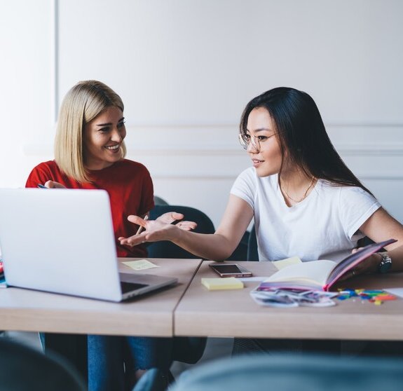 Multiethnic women working with laptop in office