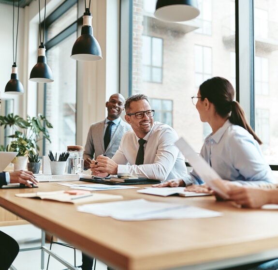 Diverse businesspeople laughing during a meeting around an offic