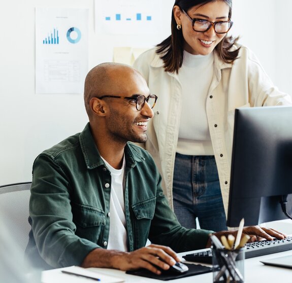 Web developers using a computer together in an office