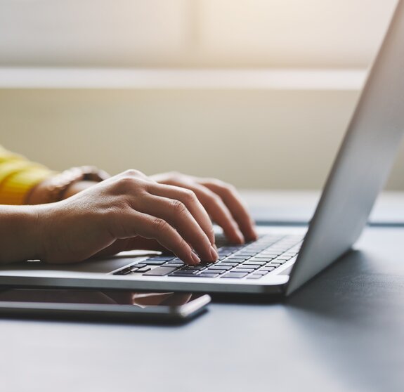 Close up of female hands while typing on laptop