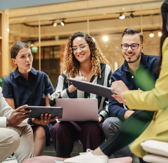 Multiethnic Group of People Meeting and Discussing Innovative Ideas in a Casual Conference Room in the Office. Smiling Colleagues Putting Together a Presentation