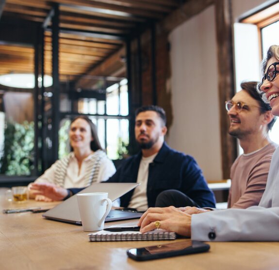 Conference meeting in an office, happy business team sits together in a boardroom