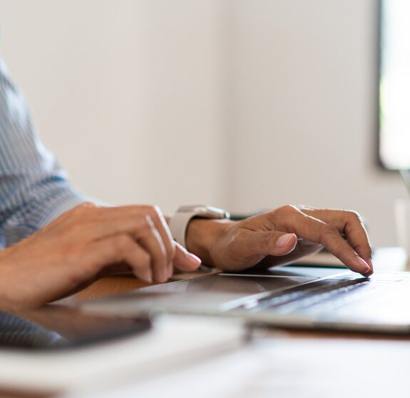 Close up hands of businesswoman typing on laptop keyboard to working and searching business data