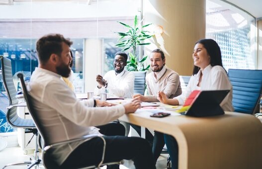 Cheerful diverse colleagues gathering on meeting in office