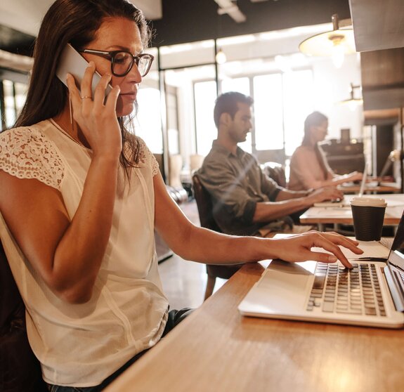 Eine Frau nimmt über Microsoft Teams per Mobiltelefon an einer Onlinebesprechung teil.