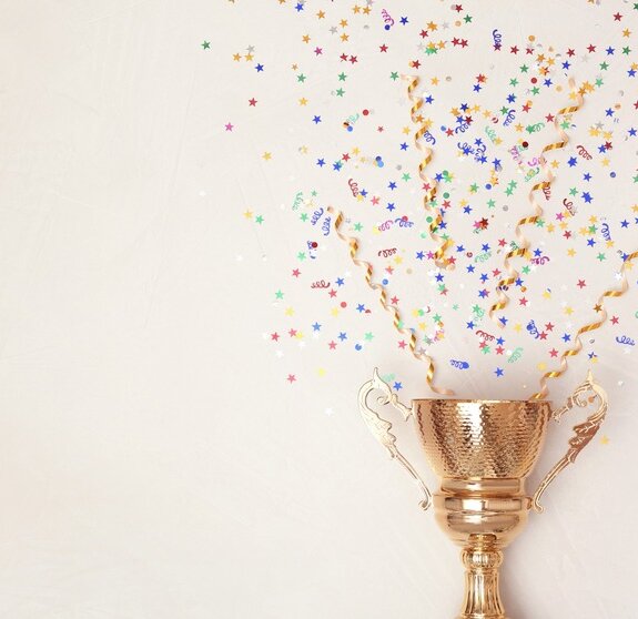 Trophy and confetti on light background, top view with space for text. Victory concept