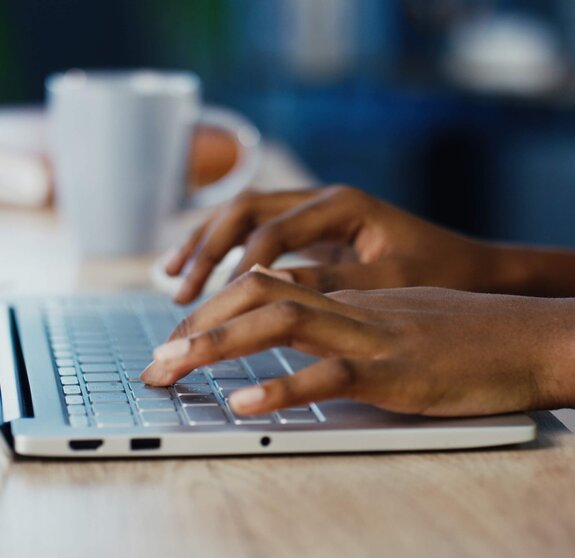 Close up shot of female hands typing on laptop