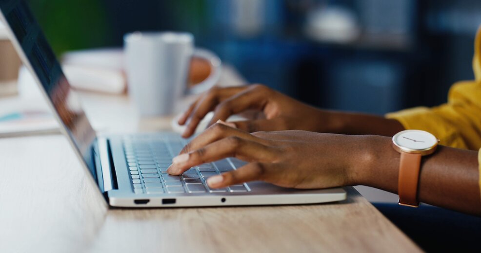 Close up shot of female hands typing on laptop