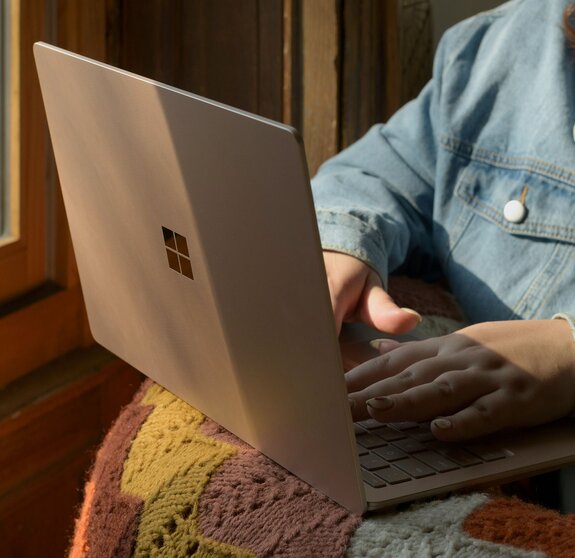 Eine Frau, die mit einem Laptop auf einem Stuhl sitzt