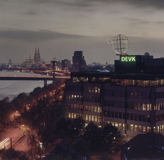 Foto der Firmenzentrale der DEVK mit Kölner Skyline im Hintergrund im Abendlicht