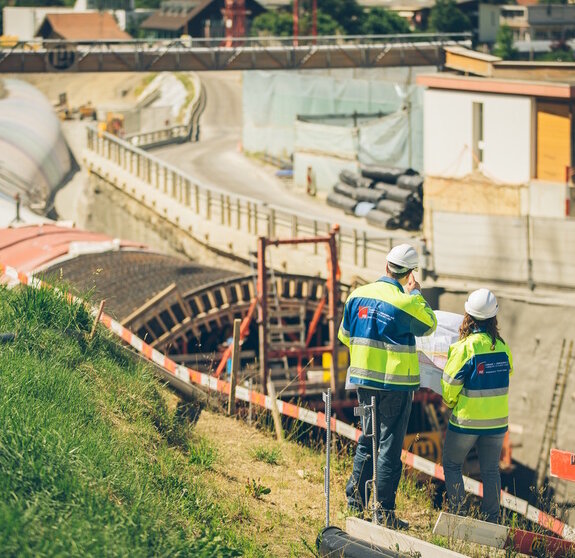 Zwei Bauarbeiter begutachten eine Baustelle