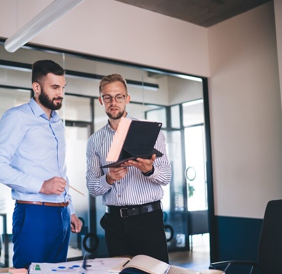 AdobeStock, zwei Männer im Büro im Austausch