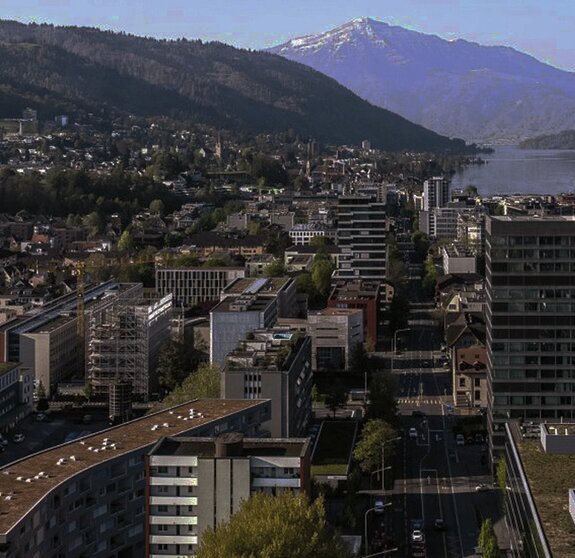 Ein Panorama der Stadt Zug mit See und Bergen im Hintergrund.